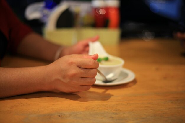 Close-up of woman hand holding drink on table