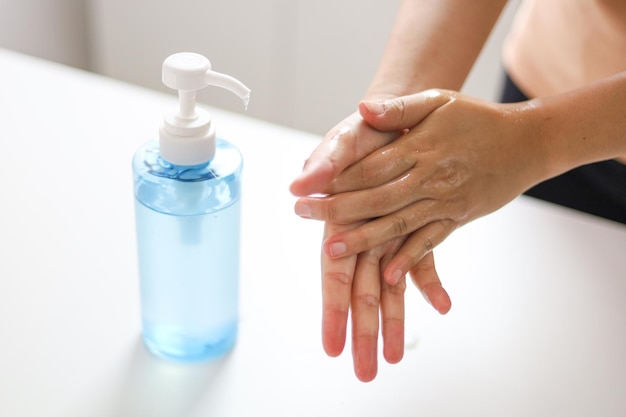 Foto close-up di una donna con la mano che tiene una bottiglia di vetro