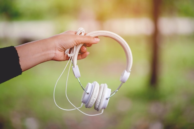 Close-up of woman hand holding headphones outdoors