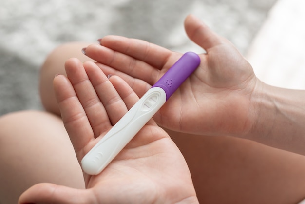 Close up of woman hand holding a positive home pregnancy test.