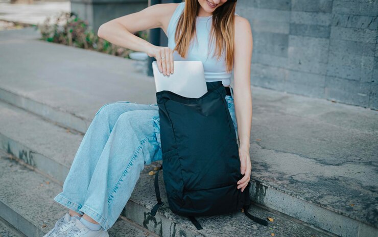 Photo 女性の手を接写し、ラップトップをバッグに入れます