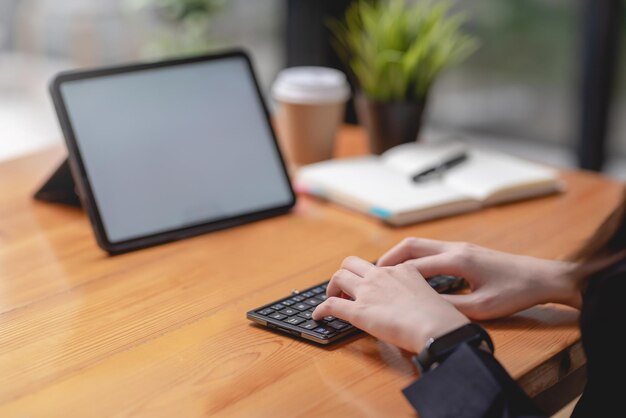 Close up of woman hand printing using the tablet computer at the office.