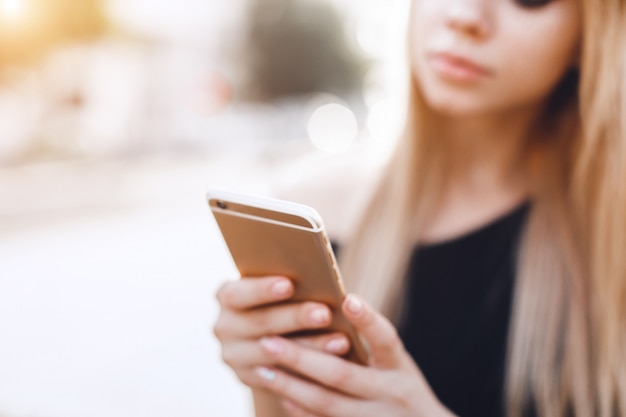 Foto chiuda sulla mano della donna facendo uso di uno smart phone