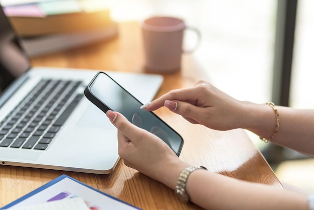 Close up. Woman hand using smartphone order goods online. Businesswoman using mobile phone working at office.