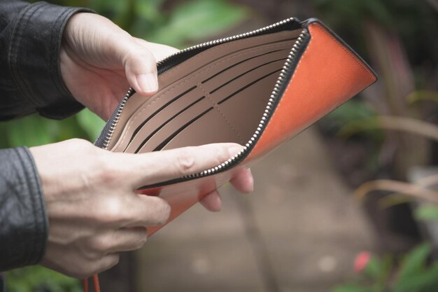 Business person holding empty purse in his hand. Stock Photo by  stockfilmstudio