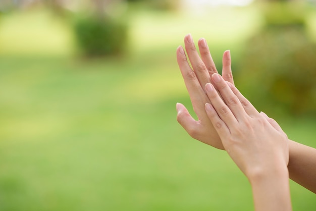 Close up woman hands is applying alcohol sanitizer outdoor