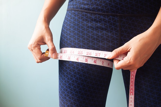 Close up woman hands measuring her legs