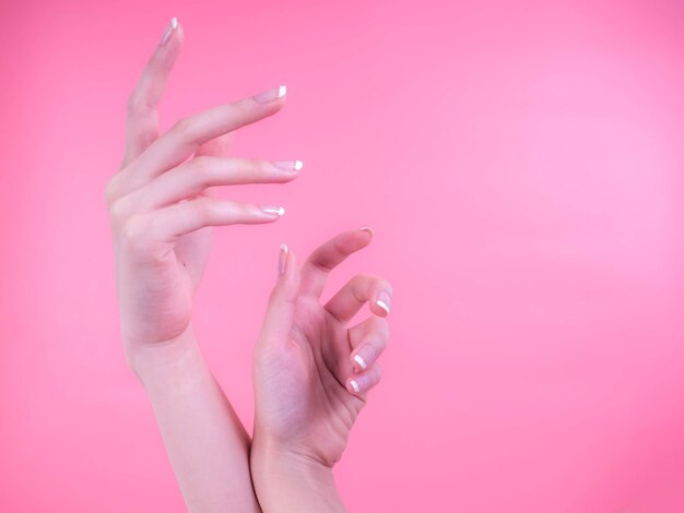 Photo close-up of woman hands over pink background