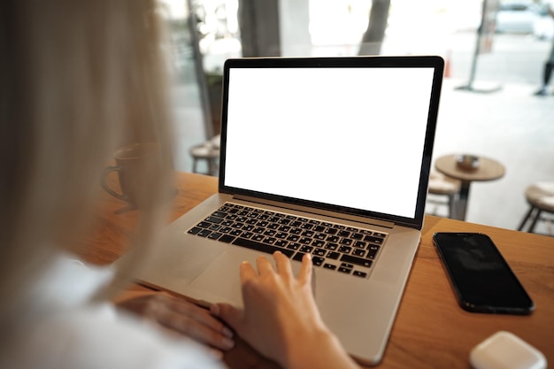 Close up of woman hands typing on laptop in cafe