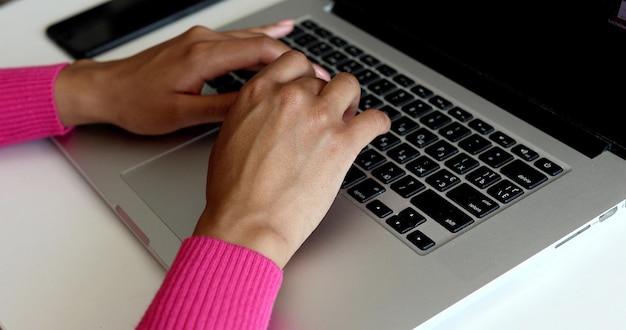 Close up of woman hands typing on laptop computer keyboard.