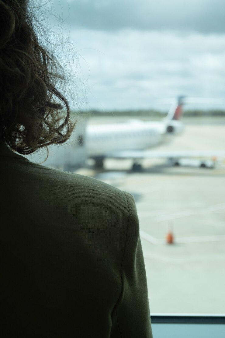 Close-up of woman on her back in front of airport runway, select focus