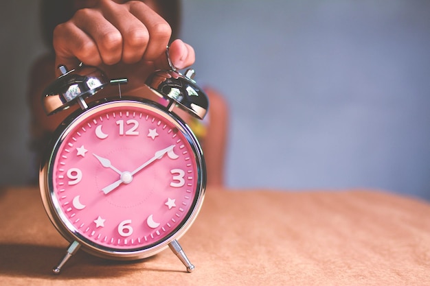 Close-up of woman holding alarm clock