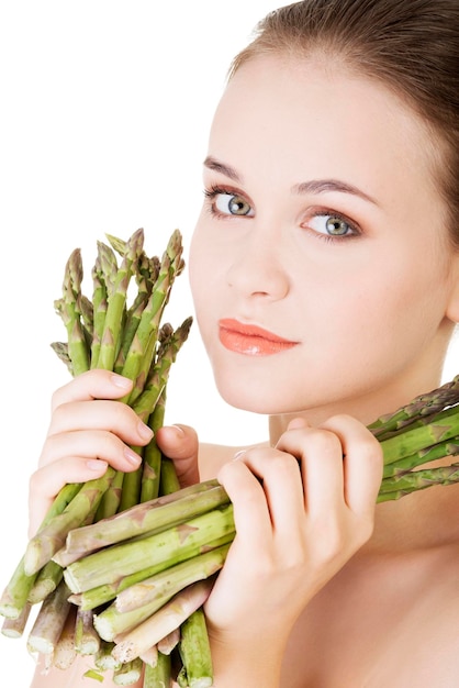 Photo close-up of woman holding asparagus against white background