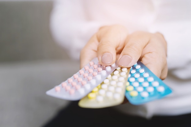 Close up woman holding birth control pills The concept methods of contraception gynecology.