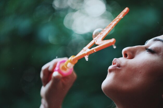 Foto close-up di una donna con una bacchetta di bolle