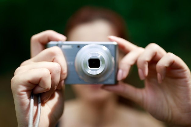 Foto close-up di una donna che tiene in mano la telecamera