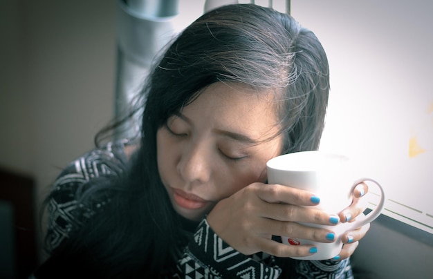 close-up of woman holding coffee cup at home