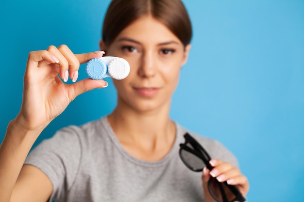 Close up of woman holding container with contact lenses