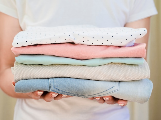 Photo close-up woman holding folded clean clothes