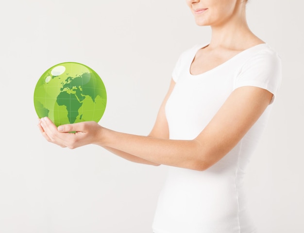 close up of woman holding green sphere globe