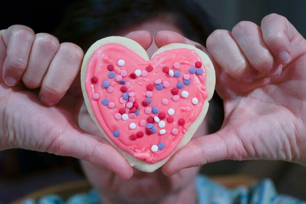 Photo close-up of woman holding heart shaped cookie