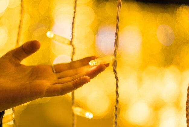 Close-up of woman holding illuminated string light