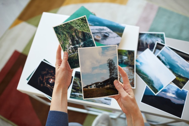 Close-up of woman holding photos in her hands remembering her best moments