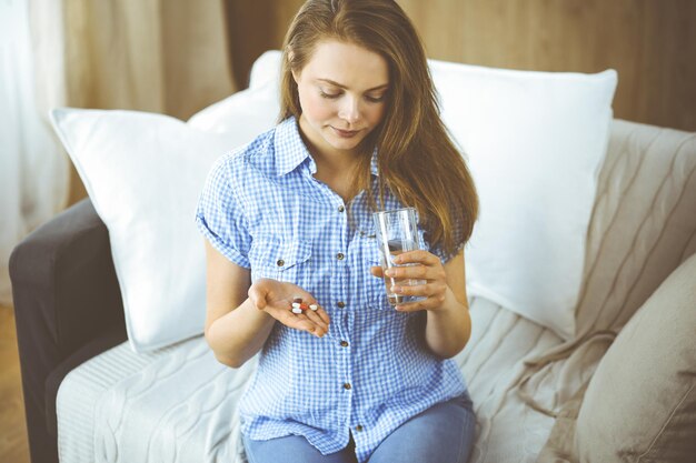 Close-up woman holding pills time to take medications, cure for\
headache, high blood pressure or cholesterol level remedy pain\
killer drugs. medicine concept.