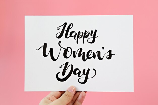 Close-up of woman holding placard with text against colored background