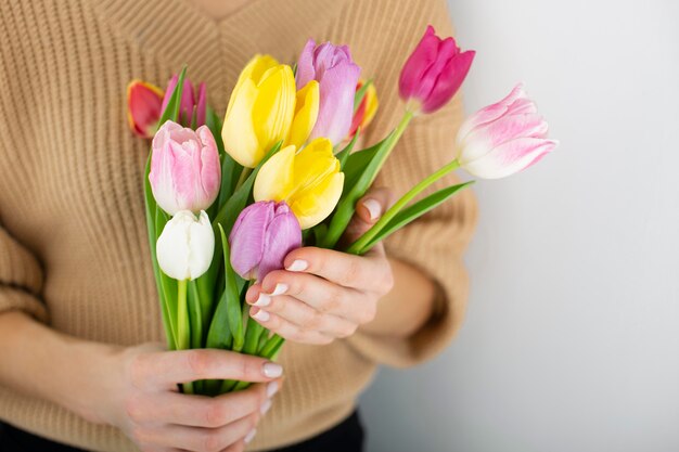 Foto chiuda sulla donna che tiene il mazzo dei tulipani