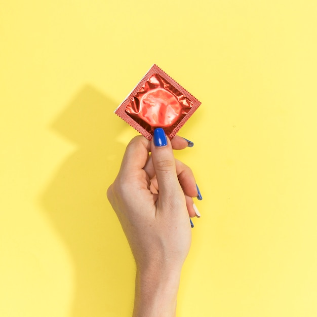 Close-up woman holding up a condom