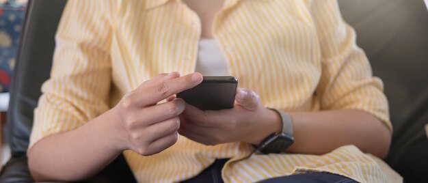 Close up woman holding and using mobile phone