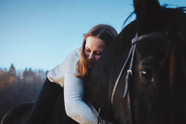 Close-up of woman hugging horse
