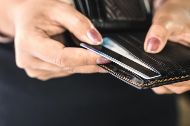 Photo close-up of woman inserting credit card in wallet