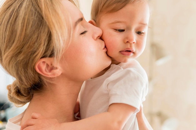 Close-up woman kissing baby