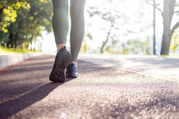 Close up woman legs in sport sneakers running in park on
sunrise time healthy fitness lifestyle