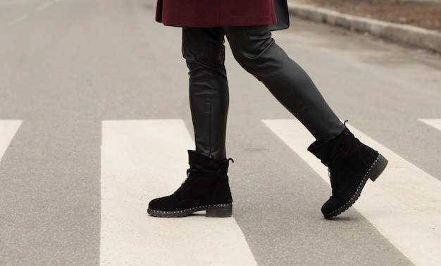 close up of woman legs walking on crosswalk.