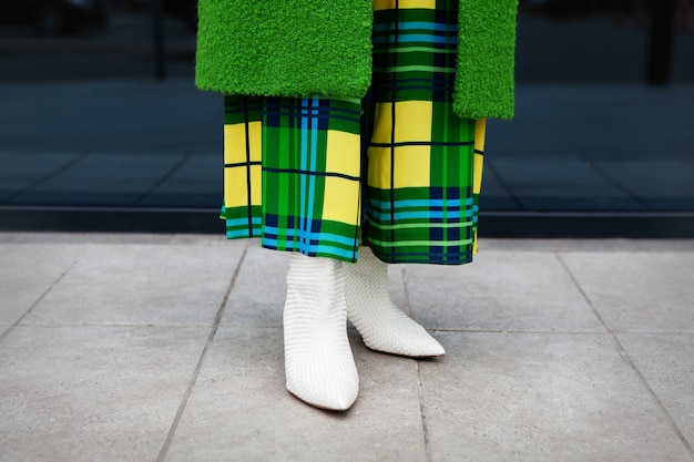 Foto close up donna gambe elegante cappotto verde vestito a scacchi giallo in pelle scarpe bianche con tacchi