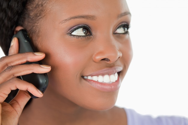 Close up of woman listening to caller on white background