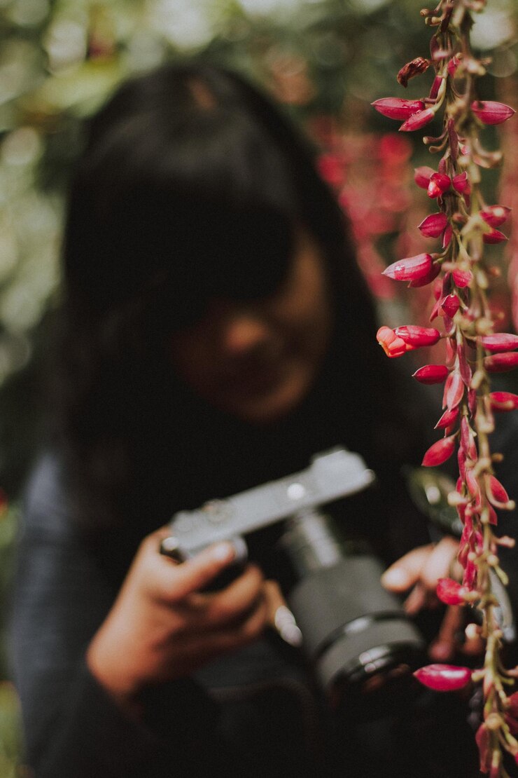 Photo close-up of woman looking at camera by flowering plant