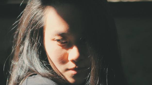 Photo close-up of woman looking down in darkroom