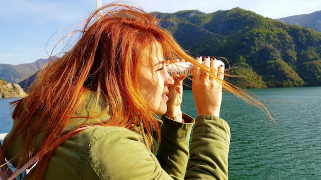 Foto close-up di una donna che guarda attraverso un oggetto