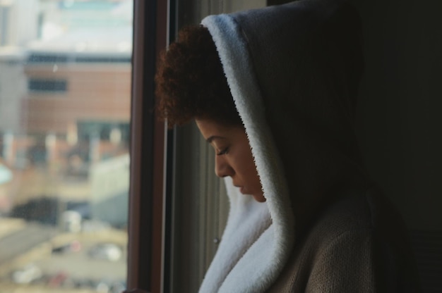 close-up of woman looking through window at home