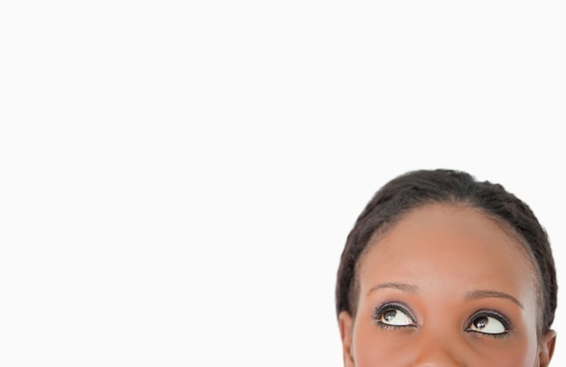 Close up of woman looking upwards diagonally on white background