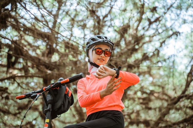 Close up of woman looking at watch while cycling