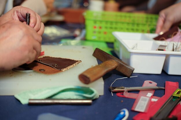 Photo close-up of woman making leather wallet