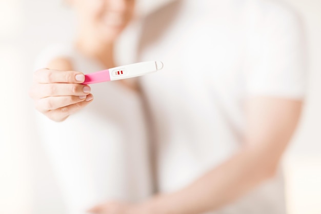 close up of woman and man hands with pregnancy test