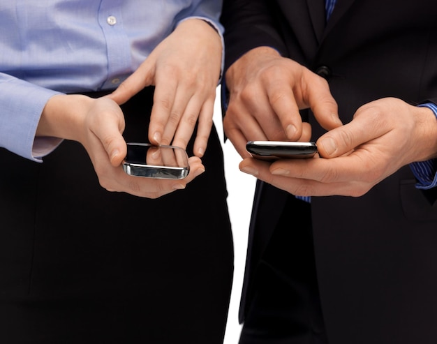 close up of woman and man hands with smartphones