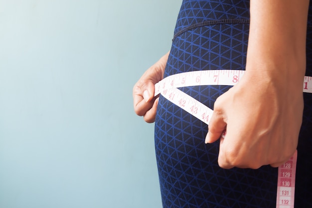 Close up woman measuring her hip