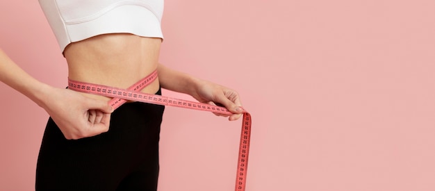 Close up woman measuring herself